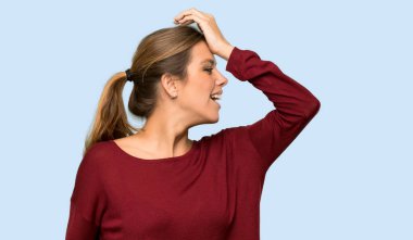 Sarışın kadın bir şey fark etti ve çözümü izole edilmiş mavi arka planda arıyor.