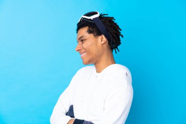 Snowboard gözlüklü genç Afrikalı Amerikalı yan tarafa bakıyor.