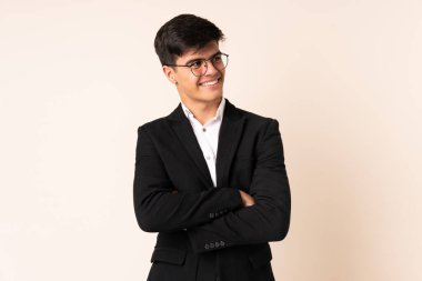 İzole edilmiş bej arka planda iş adamı yana bakıyor