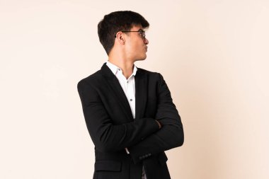 İzole edilmiş bej arka planda gülen bir iş adamı