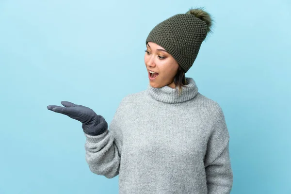 Jovem Uruguaia Com Chapéu Inverno Isolado Fundo Azul Segurando Copyspace — Fotografia de Stock