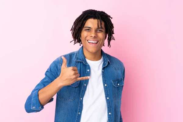 若いですアフリカ系アメリカ人男とともにJeanシャツ上の隔離されたピンクの背景作り電話ジェスチャー — ストック写真