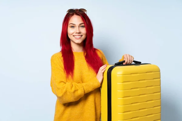 旅行女孩拿着一个蓝色背景的手提箱 双臂交叉放在正面位置 — 图库照片