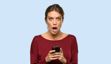 Sarışın kadın şaşırdı ve mavi arka planda bir mesaj gönderiyor.