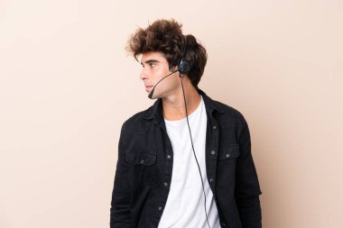 Tele pazarlamacı, arka planda izole edilmiş bir kulaklıkla çalışıyor.