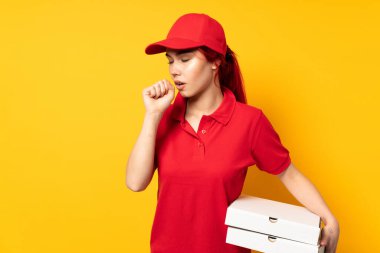 Pizzacı kız arka planda pizza tutuyor ve öksürüyor.
