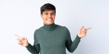 Soyutlanmış mavi arka planda yakışıklı bir adam parmak ucunda ve mutlu.