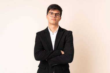 İzole edilmiş bej geçmişi olan bir iş adamı kollarını kavuşturuyor.