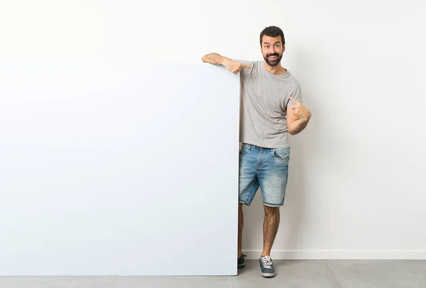 Jovem Homem Bonito Com Barba Segurando Grande Cartaz Azul Vazio — Fotografia de Stock