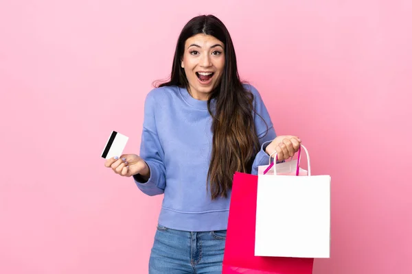 Junge Brünette Mädchen Über Isolierten Rosa Hintergrund Mit Einkaufstaschen Und — Stockfoto