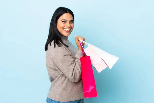 Jong Latin Vrouw Vrouw Geïsoleerd Blauwe Achtergrond Met Winkeltassen Glimlachen — Stockfoto