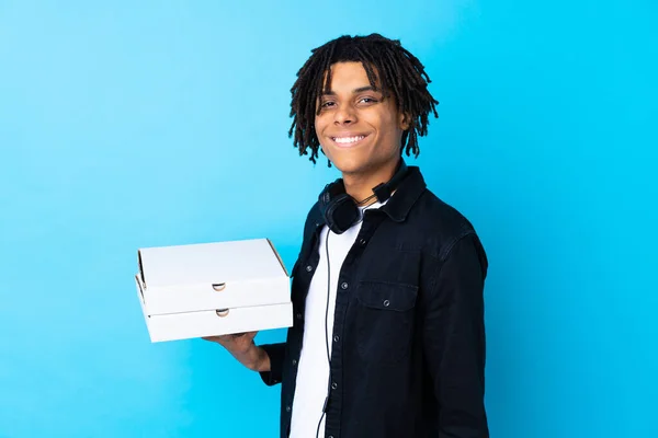 Junger Afroamerikanischer Mann Hält Pizzakartons Über Isolierte Blaue Wand Und — Stockfoto