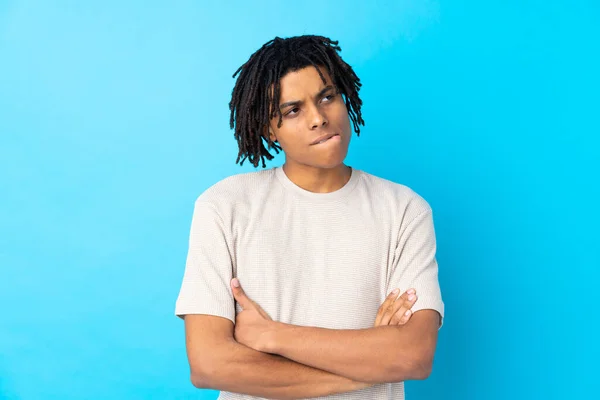 Junger Afroamerikaner Vor Isoliertem Blauen Hintergrund Mit Verwirrtem Gesichtsausdruck — Stockfoto