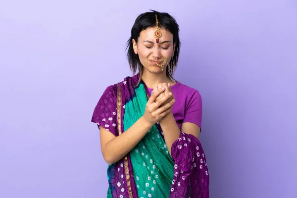 Indian woman isolated on purple background suffering from pain in hands