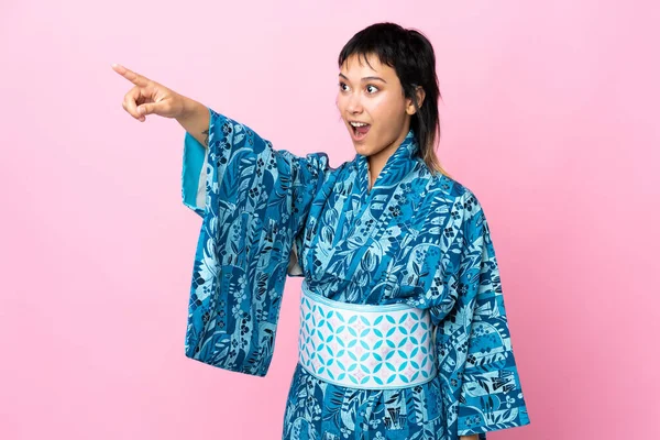 Jonge Vrouw Dragen Kimono Geïsoleerde Blauwe Achtergrond Wijzend Weg — Stockfoto