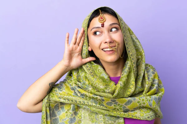 Mujer India Aislada Sobre Fondo Púrpura Escuchando Algo Poniendo Mano —  Fotos de Stock