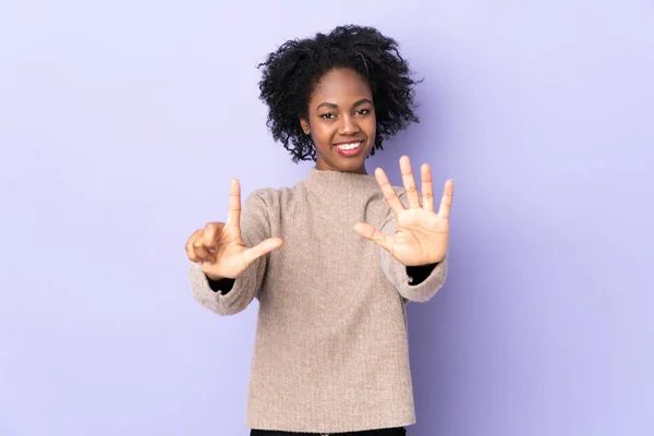 아프리카계 여성은 보라색 배경에 고립되어 손가락으로 일곱을세었다 — 스톡 사진