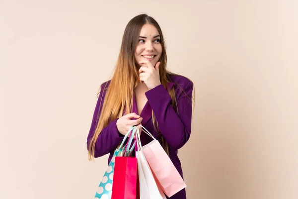 Ung Kaukasisk Kvinna Isolerad Beige Bakgrund Håller Shoppingväskor Och Ler — Stockfoto