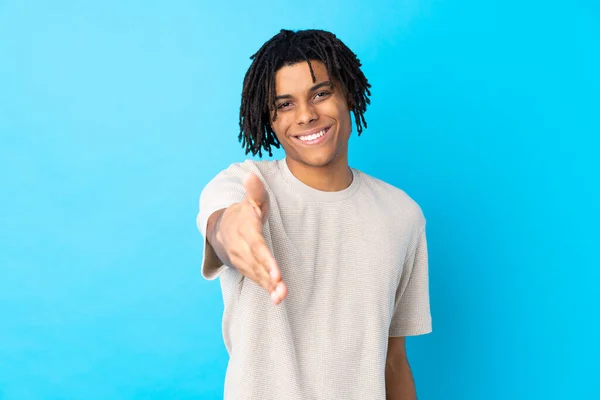 Jovem Afro Americano Sobre Fundo Azul Isolado Apertando Mãos Para — Fotografia de Stock