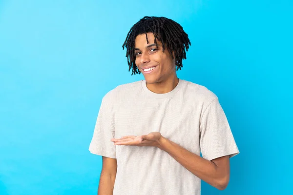 Junger Afroamerikanischer Mann Auf Isoliertem Blauem Hintergrund Präsentiert Eine Idee — Stockfoto
