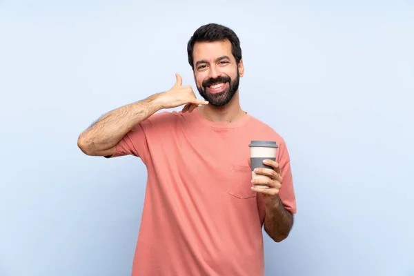 Jongeman Met Baard Die Een Afhaalkoffie Vasthoudt Geïsoleerde Blauwe Achtergrond — Stockfoto