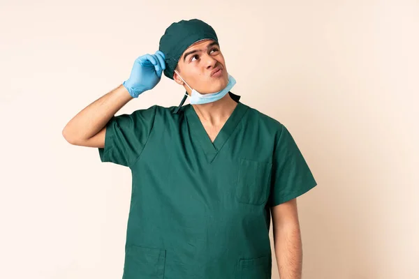 身穿蓝色制服的外科医生 背景偏僻 有疑问 面部表情混乱 — 图库照片