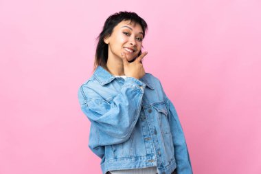 Genç Uruguaylı kadın pembe arka planda mutlu ve gülümsüyor.