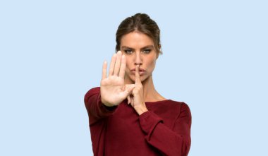 Sarışın kadın, mavi arka planda yanlış düşünen bir durumu inkar etmekten vazgeçiyor.