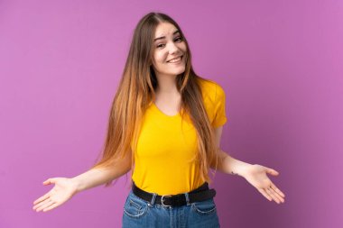 Mor arka planda izole edilmiş genç beyaz kadın mutlu ve gülümsüyor.