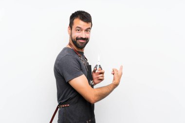 Önlüklü berber arkasını gösteriyor.