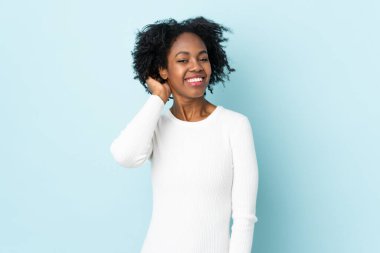 Genç Afrikalı Amerikalı kadın mavi arka planda izole edilmiş gülüyor.