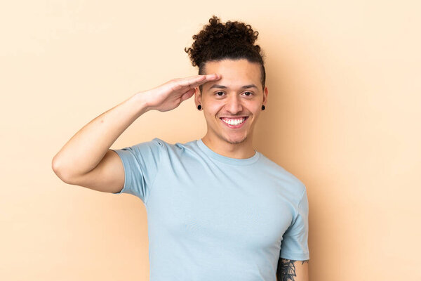Caucasian man over isolated background saluting with hand with happy expression