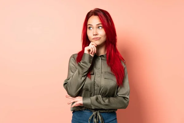 Tiener Rood Haar Meisje Geïsoleerd Roze Achtergrond Met Twijfels Denken — Stockfoto