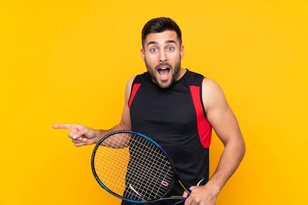 Tennis Player Man Isolated Yellow Wall Surprised Pointing Finger Side — Stock Photo, Image