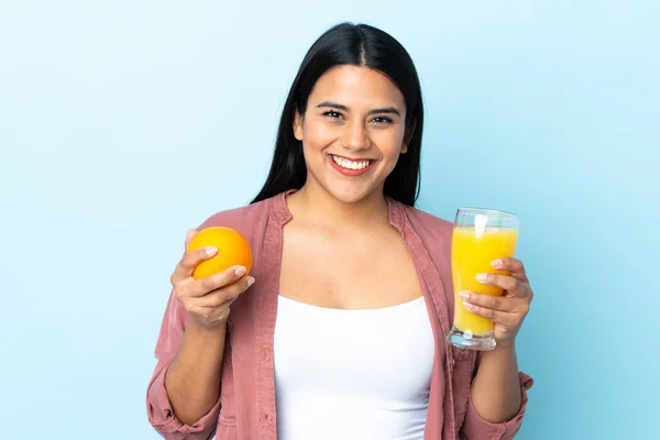 Ung Latinamerikansk Kvinna Isolerad Blå Bakgrund Håller Orange Och Apelsinjuice — Stockfoto