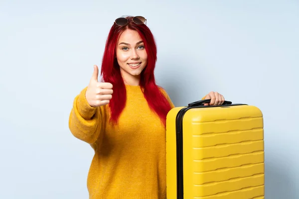 Viajante Menina Segurando Uma Mala Isolada Fundo Azul Com Polegares — Fotografia de Stock