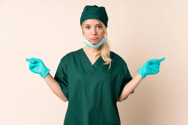 Chirurg Žena Zelené Uniformě Přes Izolované Pozadí Ukazuje Laterály Které — Stock fotografie