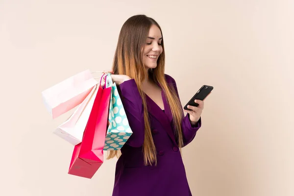 Joven Mujer Caucásica Aislada Sobre Fondo Beige Sosteniendo Bolsas Compras — Foto de Stock