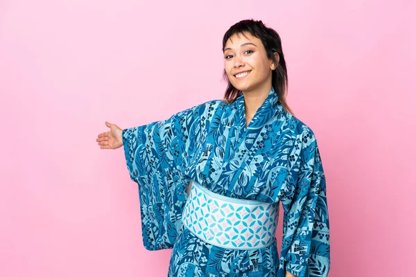 Młoda Kobieta Ubrana Kimono Odizolowanym Niebieskim Tle Wyciągając Ręce Bok — Zdjęcie stockowe