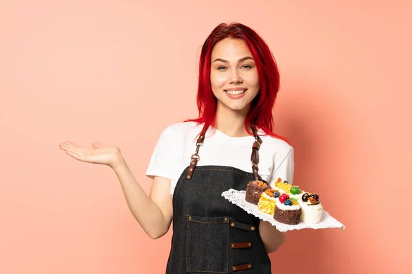 Pastelero Sosteniendo Una Magdalena Aislada Sobre Fondo Rosa Sosteniendo Espacio —  Fotos de Stock