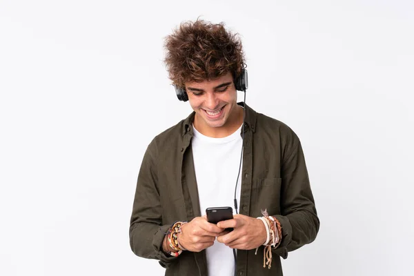 Joven Hombre Guapo Escuchando Música Con Móvil Sobre Una Pared —  Fotos de Stock