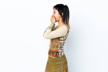 Genç Uruguaylı kız izole edilmiş beyaz arka planda ağzını kapatıyor ve yan tarafa bakıyor.