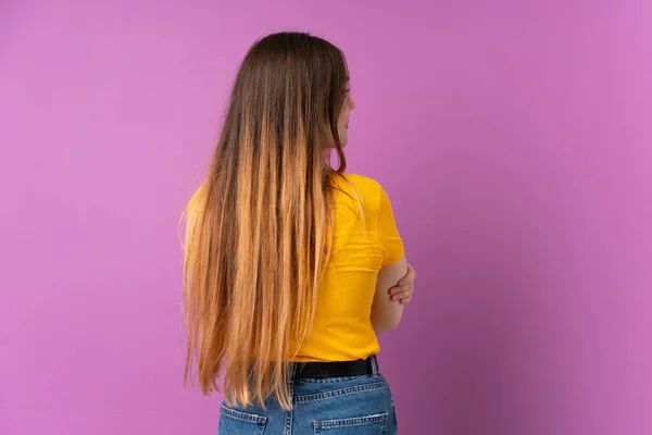 Mulher Caucasiana Jovem Isolado Fundo Roxo Posição Traseira Olhando Lado — Fotografia de Stock