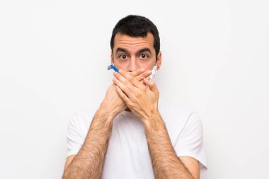 Sakalını kesen bir adam izole edilmiş beyaz arka planda ağzı elleriyle kapatıyor.