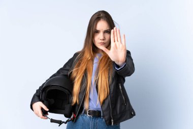 Motosiklet kasklı bir kadın eliyle jest yapıyor.