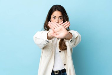 İzole edilmiş arka planda kalan bir kadın bir eylemi durdurmak için el hareketini durduruyor.