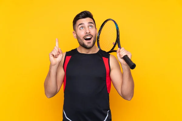Άντρας Πάνω Από Απομονωμένο Κίτρινο Φόντο Παίζει Τένις Και Δείχνει — Φωτογραφία Αρχείου