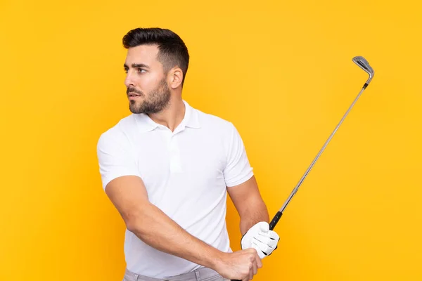 在孤立的黄色背景上打高尔夫的男人 — 图库照片