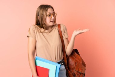 Pembe arka planda izole edilmiş genç Ukraynalı kız avuç içinin üzerinde sanal bir kopyalama alanı tutuyor.