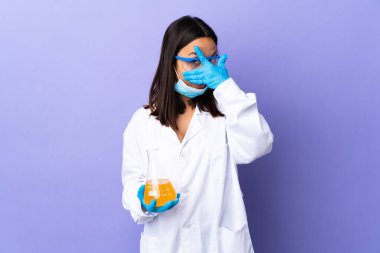 Koronavirüs hastalığını tedavi eden bir aşıyı araştıran bilim adamı kadın gözleri kaplıyor ve gülümsüyor.